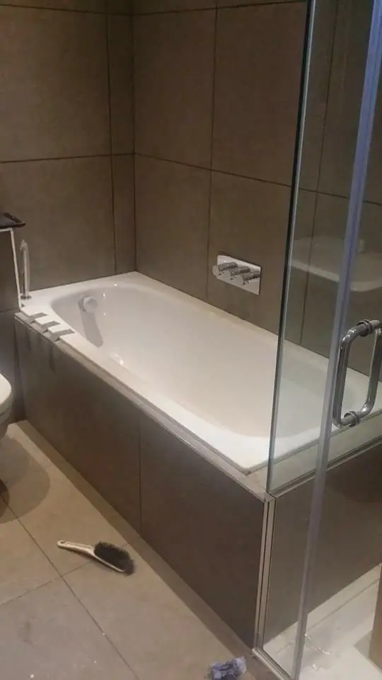 New bath with tiled panel and glass shower screen