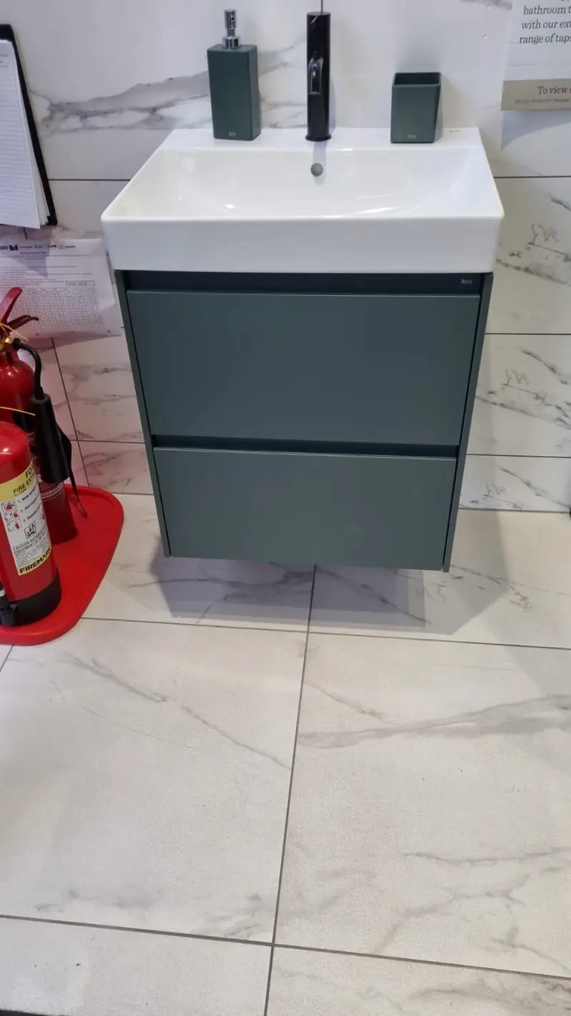 Teal vanity unit with basin on a marble-effect floor